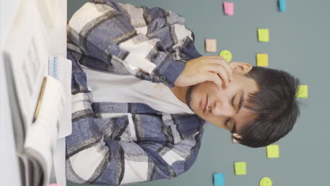 Vertical-video-of-Male-student-falls-asleep-while-studying.
